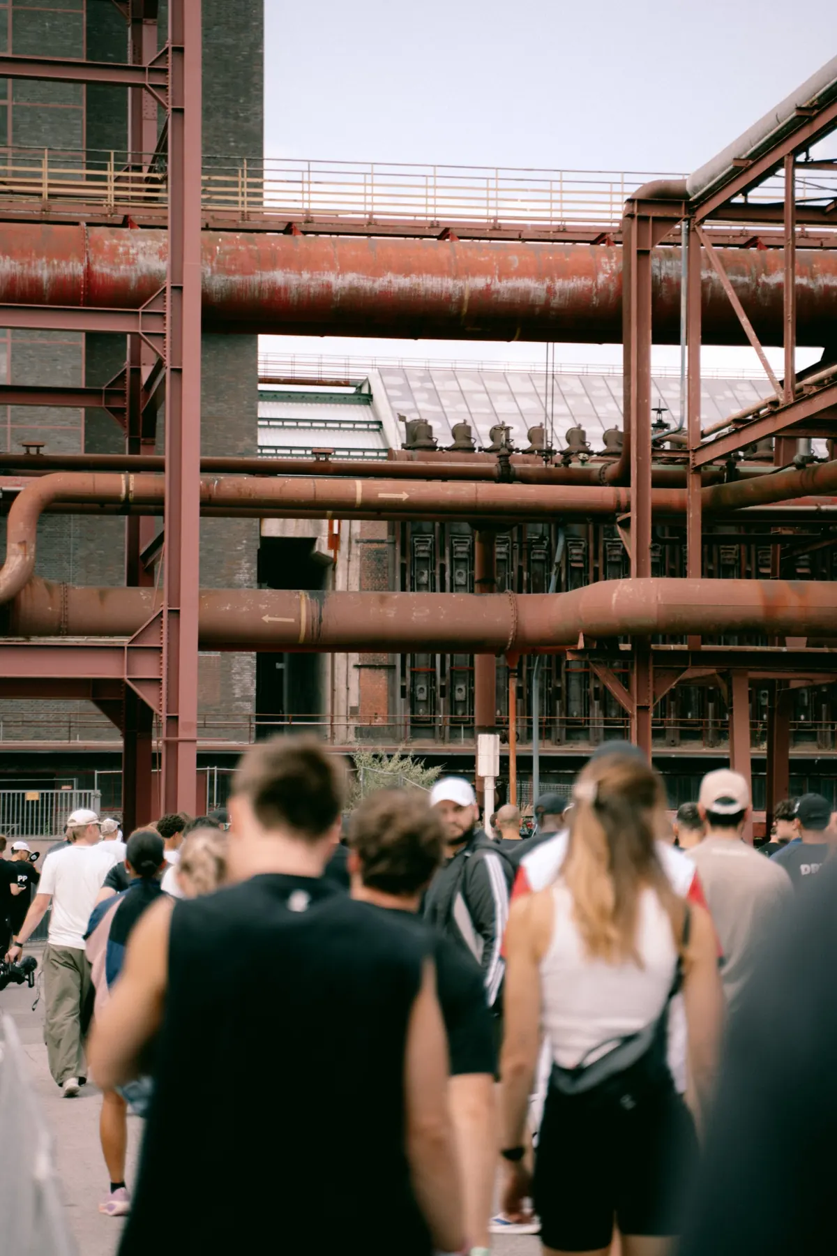 Athletes walking under the pipe bridges of Zeche Zollverein
